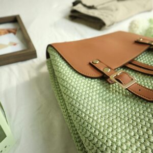 Close-up of a handcrafted crochet bag with leather accents, artistic home decor setting.